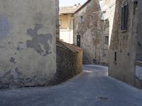 a woman with a white bag walking through an old town with stairs and buildings on either side