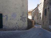 a woman with a white bag walking through an old town with stairs and buildings on either side