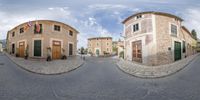 a view of the town from this side street to the outside, a man with a camera is sitting on a bench