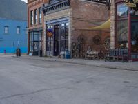 a red fire hydrant sitting in front of an old store window and building next to an open air field