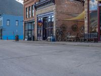 a red fire hydrant sitting in front of an old store window and building next to an open air field