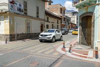 a red yellow and white checkered crosswalk on a street with cars parked next to it