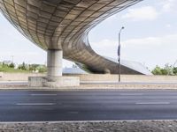 the curved overpass of an office building has an american flag hanging on it's side