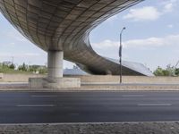 the curved overpass of an office building has an american flag hanging on it's side