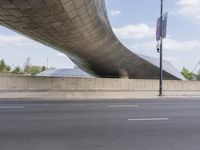 the curved overpass of an office building has an american flag hanging on it's side