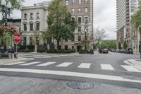 a street has an intersection and a stop sign in the middle of it next to tall buildings