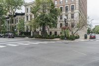 a street has an intersection and a stop sign in the middle of it next to tall buildings