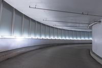 an empty parking garage with glass partition walls, in the middle of it is an empty walkway