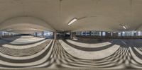 an empty parking garage with an oval mirror above it and the shadows cast on the pavement