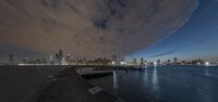 a city skyline lit up with a full view from the water's edge at night