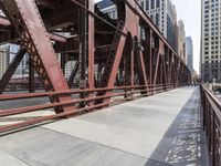 a man is riding his bike across the street on this bridge next to buildings in chicago