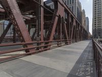 a man is riding his bike across the street on this bridge next to buildings in chicago