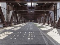 a view of a bridge from a train platform, looking at the shadows cast on the bridge
