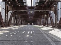 a view of a bridge from a train platform, looking at the shadows cast on the bridge