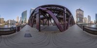 an image of a bridge and the city as seen from above it in this fish eye lens