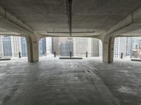 a room with no one on it and large columns, overlooking the city skyline as seen from inside