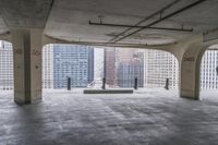 a room with no one on it and large columns, overlooking the city skyline as seen from inside