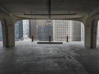 a room with no one on it and large columns, overlooking the city skyline as seen from inside