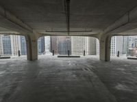 a room with no one on it and large columns, overlooking the city skyline as seen from inside