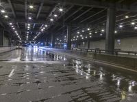 wet asphalt roadway with light spots and a street sign, in the middle of the night