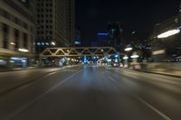 blurred photo at night of city street and highway with roadway lights in motion passing over road