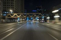 blurred photo at night of city street and highway with roadway lights in motion passing over road