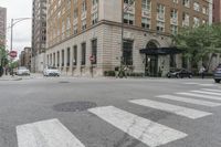 two men walk in front of an apartment building across from a red stop sign on the street