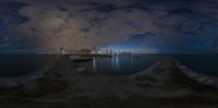 the view of some large city from a long pier near water at night in a mirror