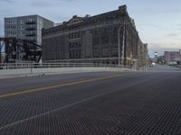 city street and a bridge over a big open area covered in metal grates,
