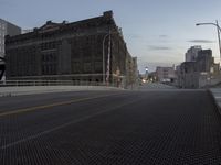 city street and a bridge over a big open area covered in metal grates,
