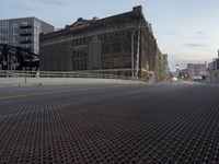 city street and a bridge over a big open area covered in metal grates,