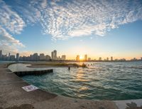 a dock with no entry sign at sunset near the water and a cityscape