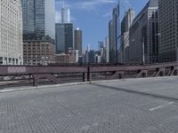 there is an empty sidewalk beside a street sign on the bridge in the city centre