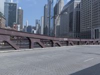 there is an empty sidewalk beside a street sign on the bridge in the city centre