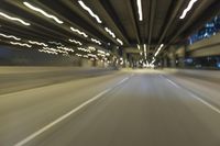 a blurry photo of the interior of an empty highway at night time and with city lights