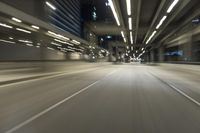 a blurry photo of the interior of an empty highway at night time and with city lights