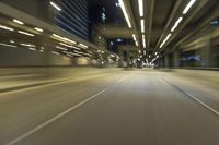 a blurry photo of the interior of an empty highway at night time and with city lights