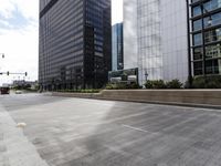 this empty city street looks beautiful, with many tall buildings in the background and empty streets