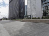 this empty city street looks beautiful, with many tall buildings in the background and empty streets