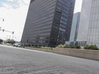 a person riding a skateboard on a paved street next to tall buildings on a sunny day