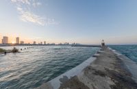 the city of mumbai from the end of a pier on a lake at sunset time