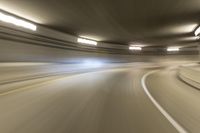 speeding through the tunnel on a highway in motion with blurry background, with light beam above it