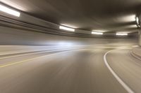 speeding through the tunnel on a highway in motion with blurry background, with light beam above it