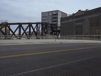 a bridge with a bicycle that is attached to it and buildings and street lights on top of it
