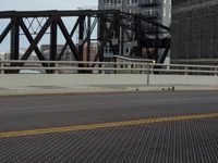 a bridge with a bicycle that is attached to it and buildings and street lights on top of it