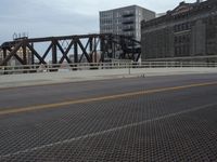 a bridge with a bicycle that is attached to it and buildings and street lights on top of it
