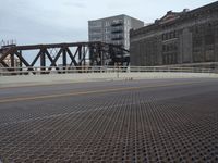 a bridge with a bicycle that is attached to it and buildings and street lights on top of it