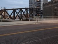 a bridge with a bicycle that is attached to it and buildings and street lights on top of it