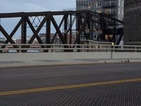 a bridge with a bicycle that is attached to it and buildings and street lights on top of it