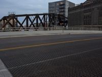 a bridge with a bicycle that is attached to it and buildings and street lights on top of it